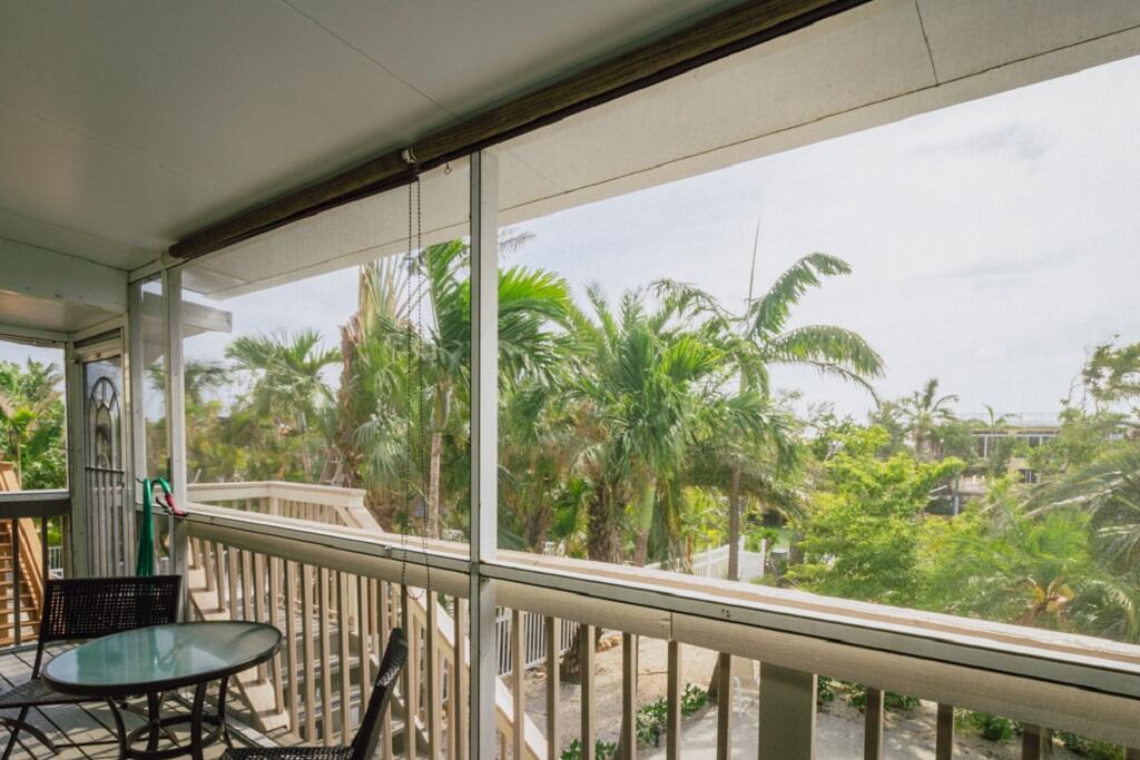 497 Sombrero Beach Road Marathon, FL 33050 - Photo 26 of 33 a view of a patio with table and chairs and floor to ceiling window with garden view