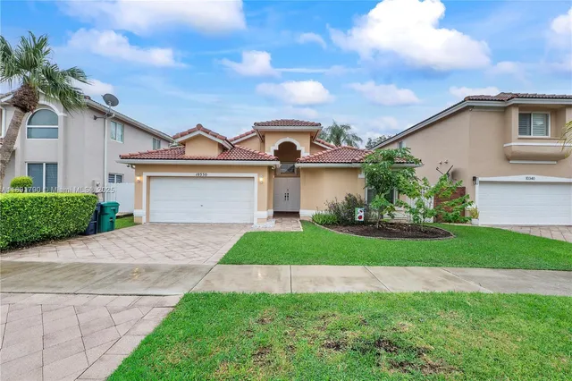 a front view of a house with a garden and plants