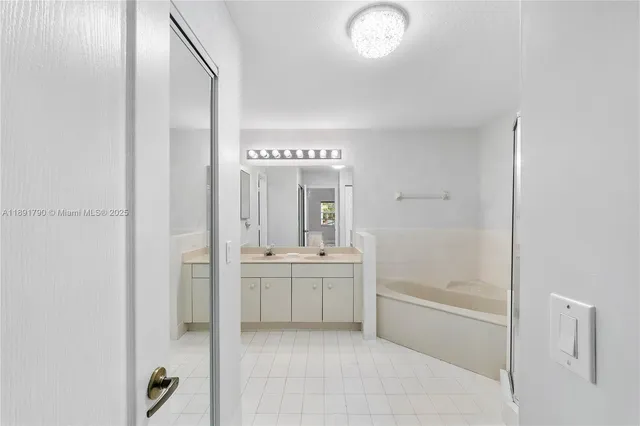 a bathroom with a tub sink and mirror