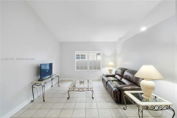 a living room with furniture a flat screen tv and a window