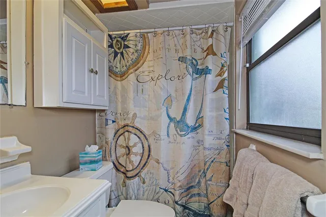 a bathroom with a toilet a sink and a shower curtain