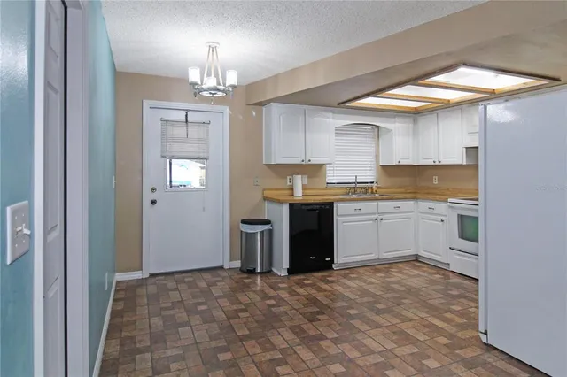 a view of a kitchen with a sink and dishwasher a stove top oven