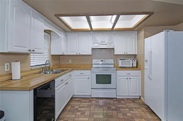 a kitchen with a sink a stove and cabinets