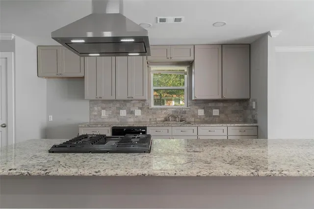 a kitchen with kitchen island granite countertop a sink stainless steel appliances and cabinets