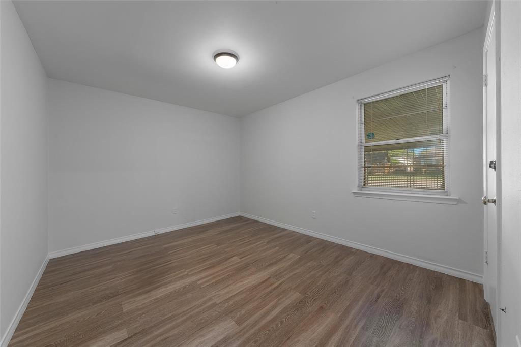 8461 Hunnicut Road Dallas, TX 75228 - Photo 23 of 30 a view of an empty room with wooden floor and a window