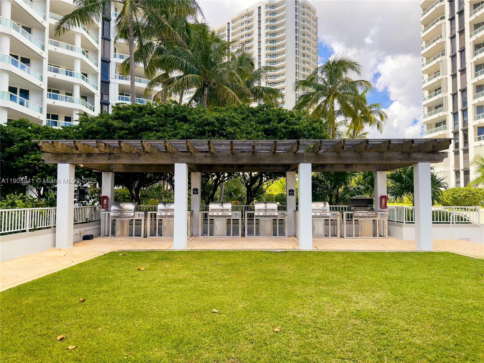21050 Point Place, Unit 401 Aventura, FL 33180 - Photo 30 of 40 a view of a chairs and table in patio with a swimming pool