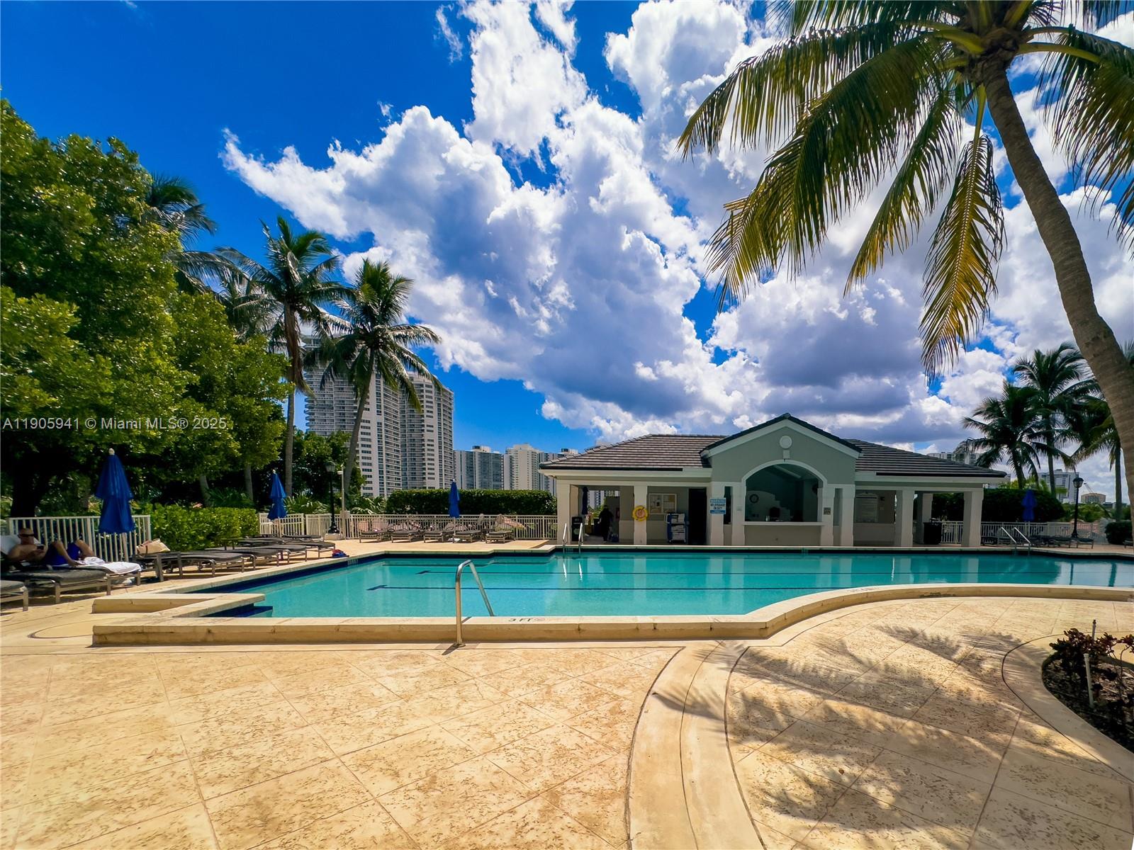 21050 Point Place, Unit 401 Aventura, FL 33180 - Photo 32 of 40 a view of a house with swimming pool and a yard