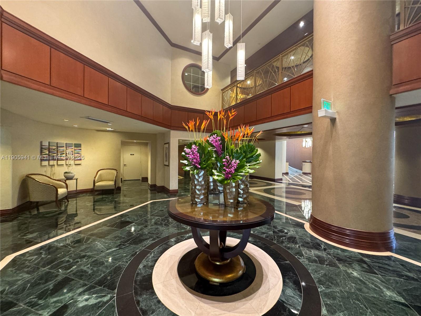 21050 Point Place, Unit 401 Aventura, FL 33180 - Photo 36 of 40 a room with lots of furniture and a chandelier