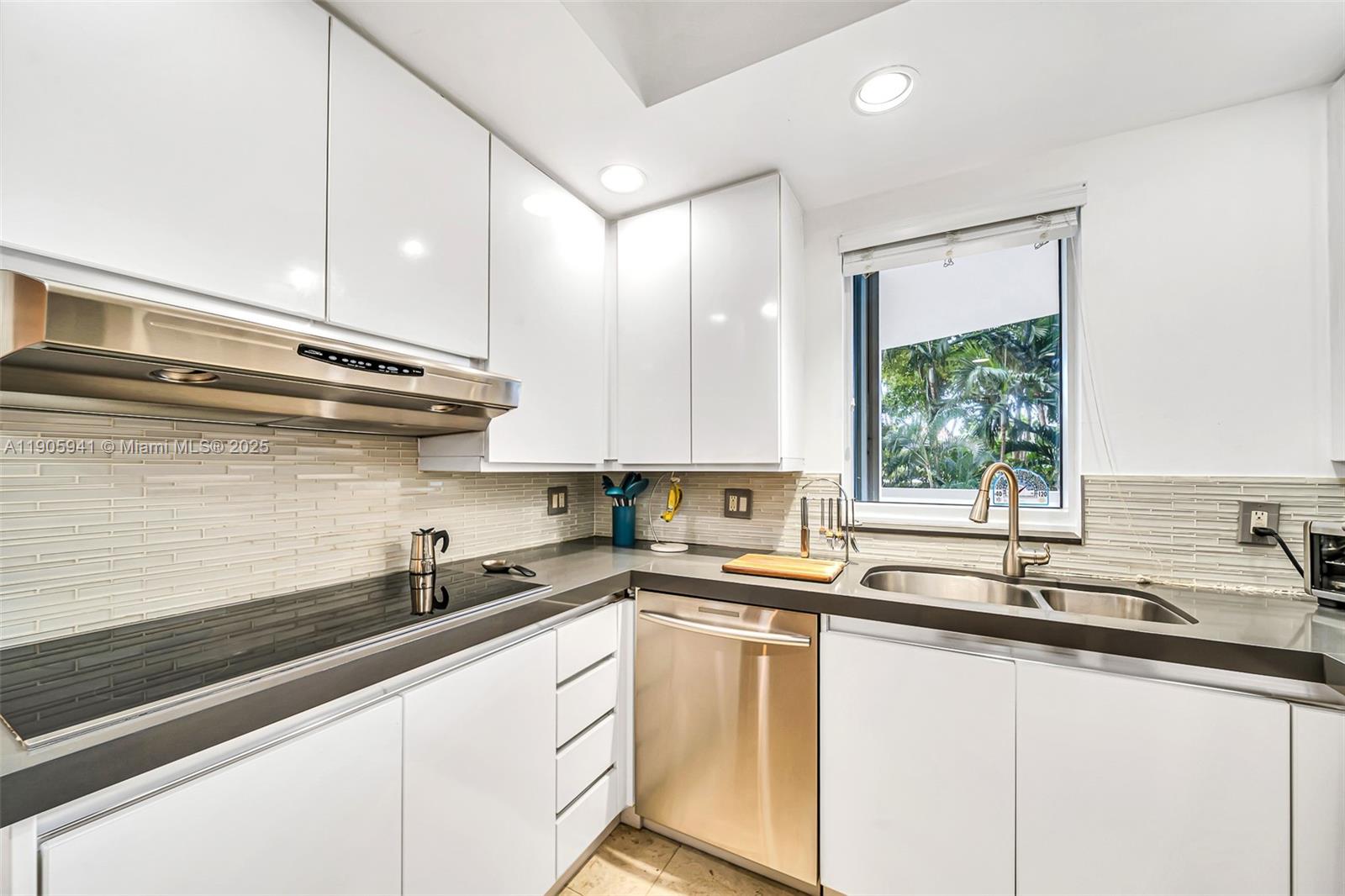 21050 Point Place, Unit 401 Aventura, FL 33180 - Photo 9 of 40 a kitchen with stainless steel appliances granite countertop a sink a stove and a wooden floors