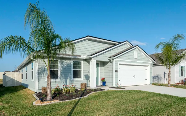 a front view of a house with a garden and yard