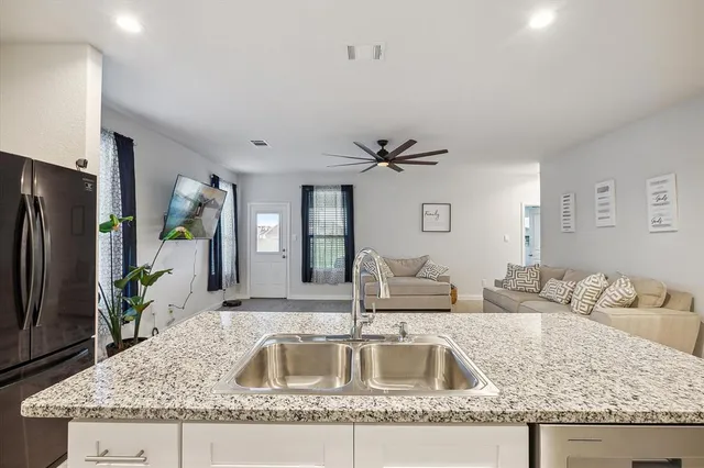 a kitchen with granite countertop a sink and a refrigerator
