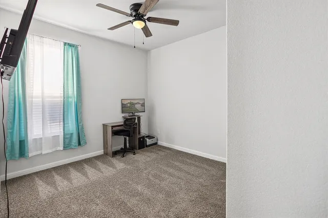 a view of a workspace with furniture and a window