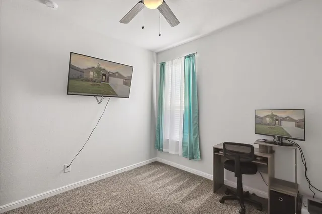 a view of a workspace with furniture and a window