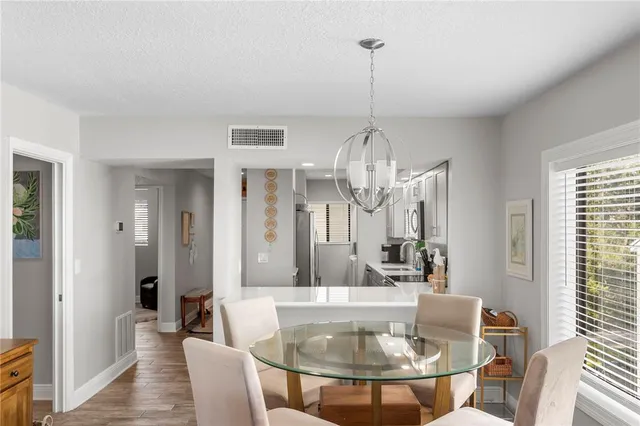 a view of a dining room with furniture a chandelier and wooden floor