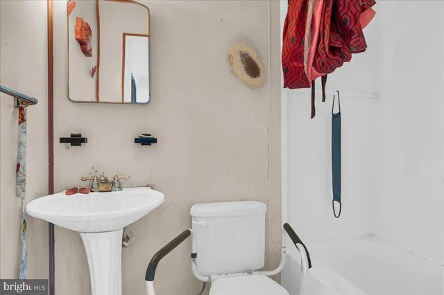 a bathroom with a sink toilet and a mirror