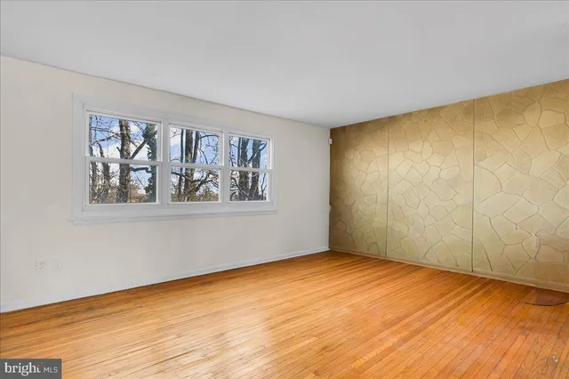 wooden floor in an empty room with a window