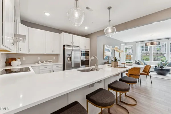 a kitchen with stainless steel appliances kitchen island a table and chairs in it