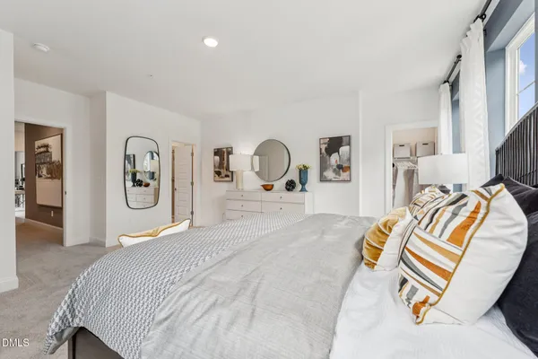 a bedroom with a bed and dresser with mirror