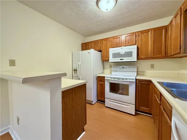 a kitchen with a refrigerator sink and cabinets