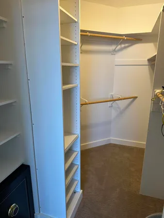a view of walk in closet with empty racks