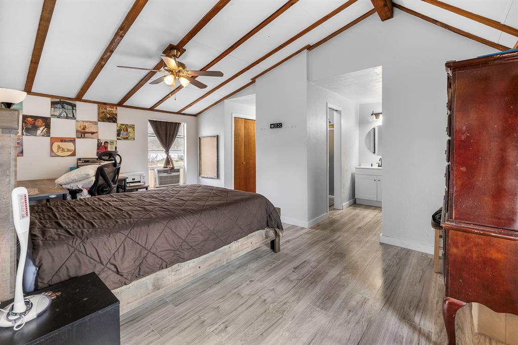 505 Alexander Road Stephenville, TX 76401 - Photo 20 of 29 a spacious bedroom with a bed and a chandelier