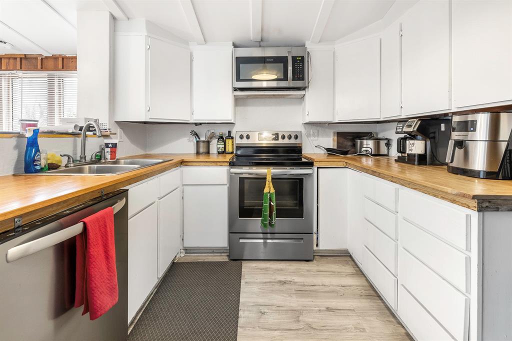 505 Alexander Road Stephenville, TX 76401 - Photo 9 of 29 a kitchen with stainless steel appliances granite countertop a stove sink and cabinets