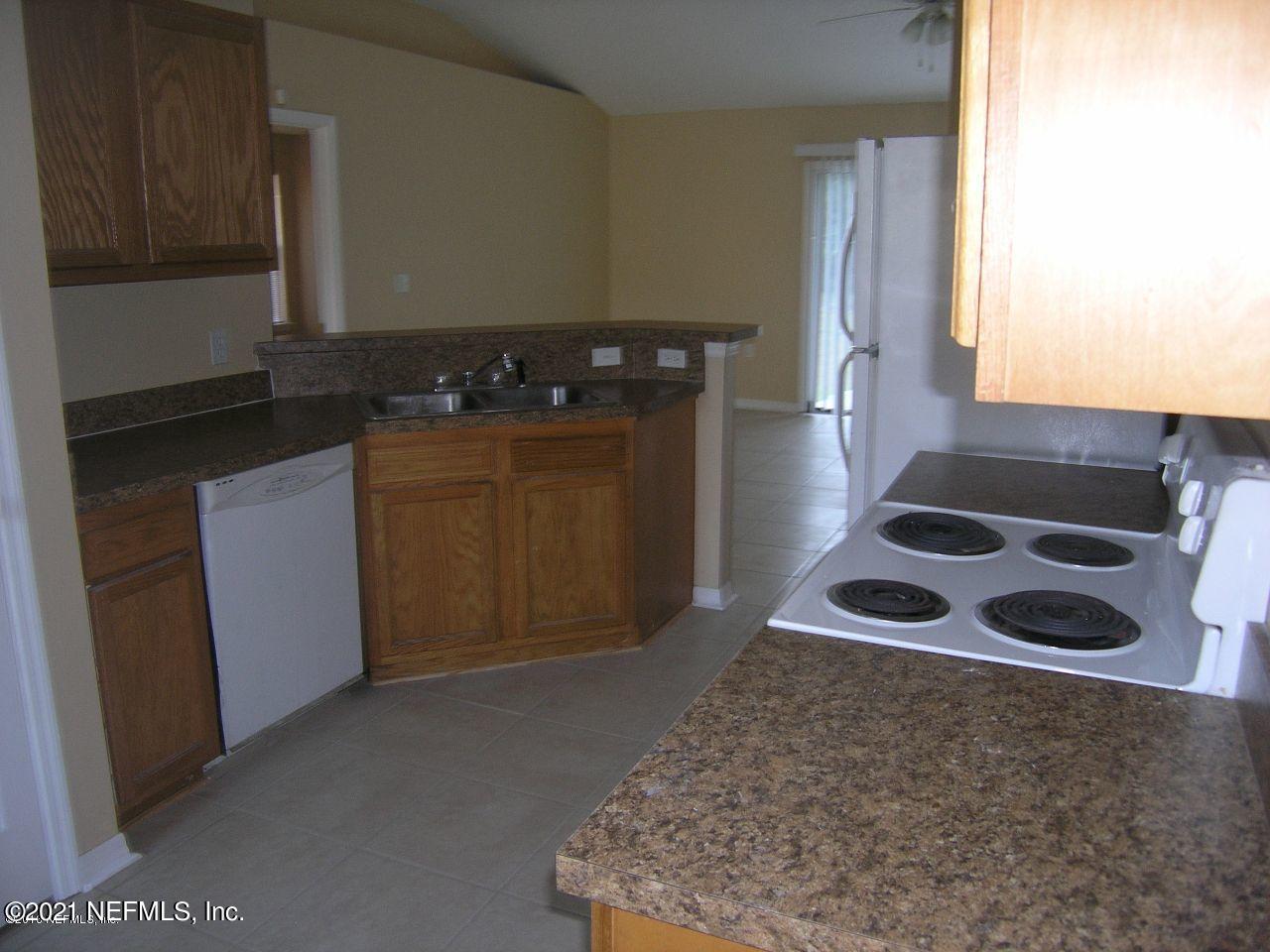 7290 Wheat Road Jacksonville, FL 32244 - Photo 3 of 4 a kitchen with a stove and a refrigerator
