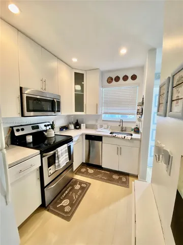 a kitchen with a stove a sink and a microwave