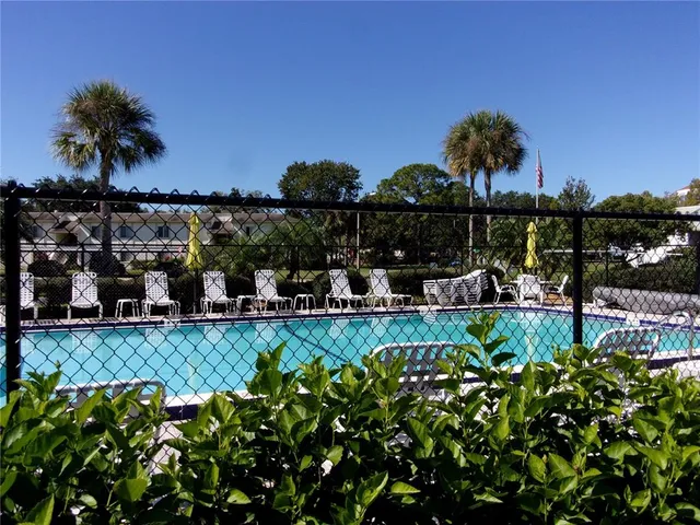 a patio with table and chairs and potted plants