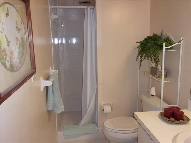 a view of a bedroom with a bed and a lamp on table