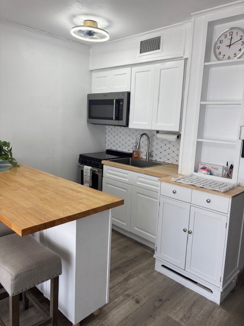3938 Surfside Boulevard, Unit 2106 Corpus Christi, TX 78402 - Photo 16 of 21 a kitchen with stainless steel appliances a sink a stove a microwave and cabinets