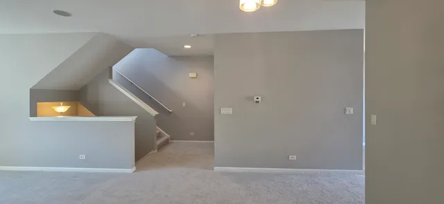 a view of an empty room with wooden floor and windows