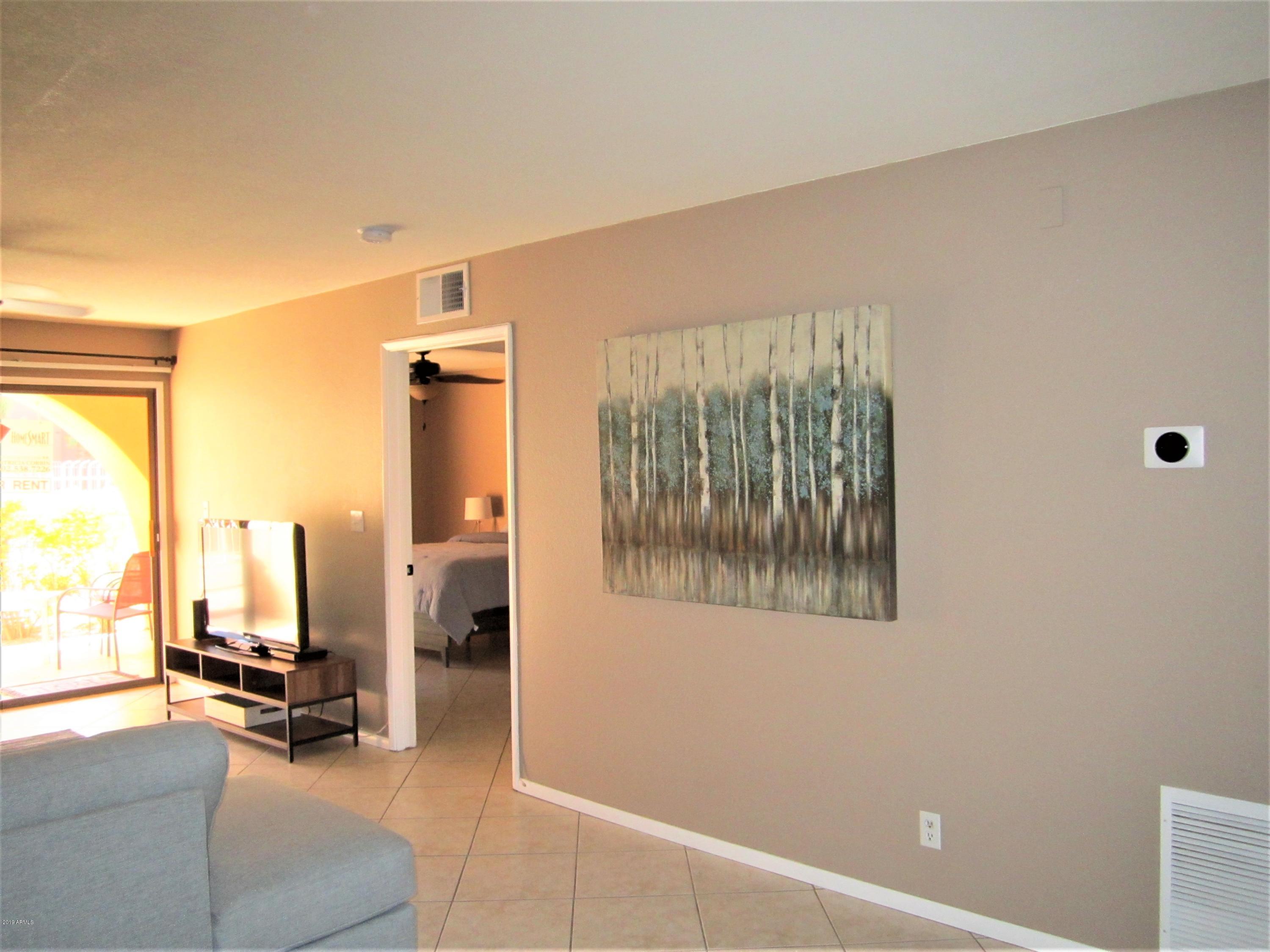 4303 East Cactus Road, Unit 116 Phoenix, AZ 85032 - Photo 9 of 35 a view of a room with gym equipment and floor to ceiling window