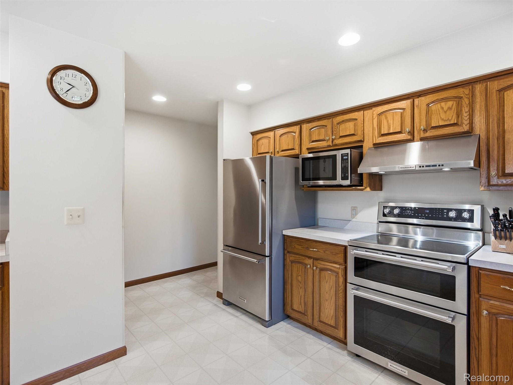 5449 Lum Road Attica, MI 48412 - Photo 38 of 82 Kitchen featuring wood cabinetry, stainless steel appliances including a double oven and microwave, recessed lighting, and light-toned tile flooring