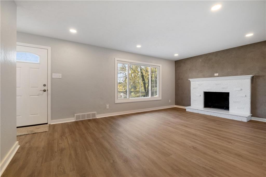 4786 Doyle Road Pittsburgh, PA 15227 - Photo 5 of 31 an empty room with wooden floor a fireplace and windows