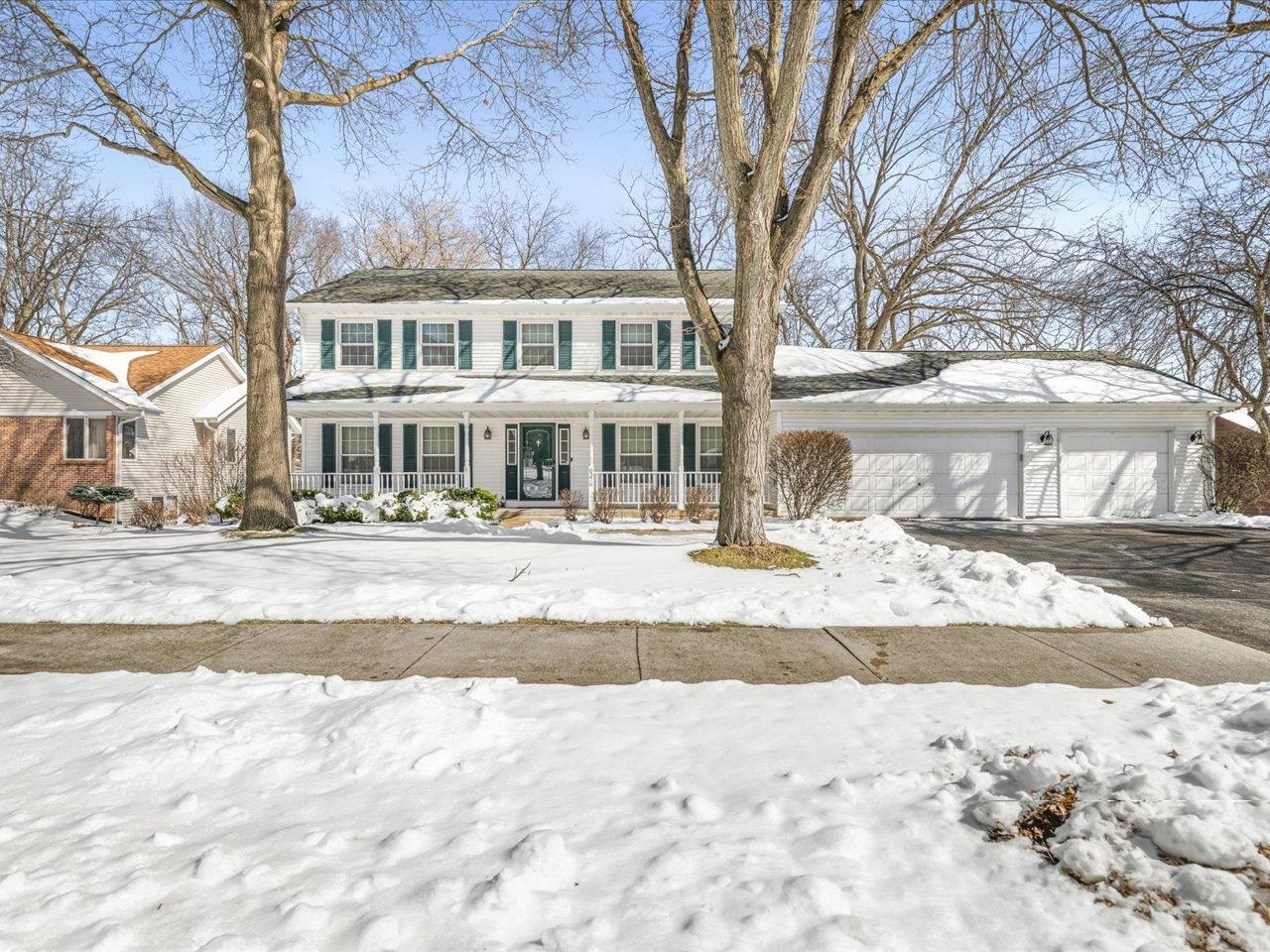 a front view of residential houses with snow on the road
