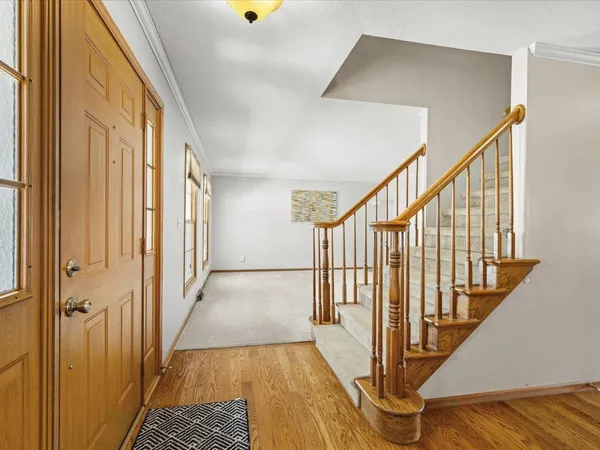 a view of a hallway with wooden floor and staircase