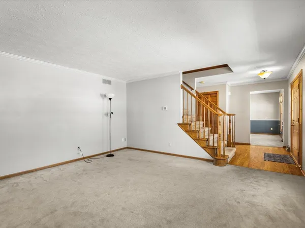 a kitchen with stainless steel appliances granite countertop a stove a sink dishwasher a refrigerator and white cabinets with wooden floor