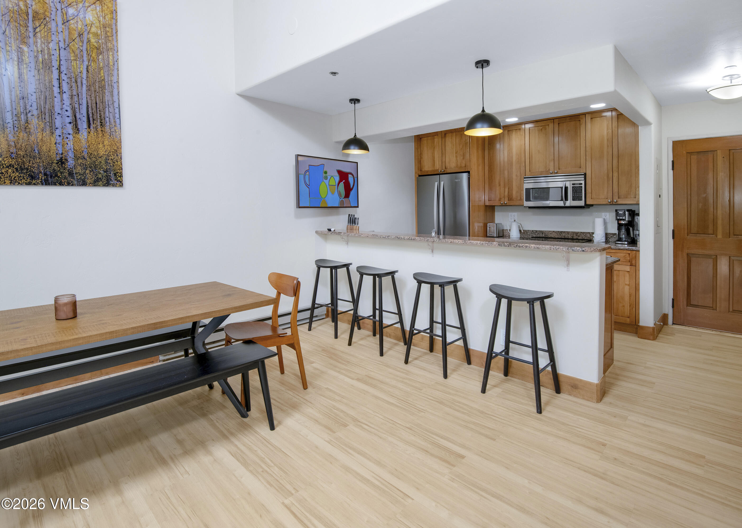 1206 Village Road, Unit B307 Beaver Creek, CO 81620 - Photo 8 of 20 a kitchen with stainless steel appliances kitchen island granite countertop a table chairs and a refrigerator