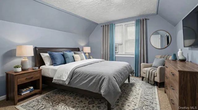 a bedroom with a bed and a lamp on dresser