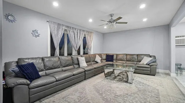 a living room with furniture and a ceiling fan