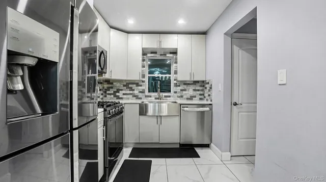 a kitchen with stainless steel appliances a refrigerator sink and cabinets