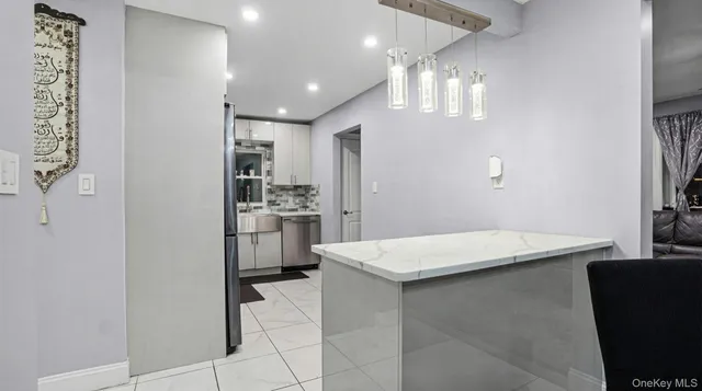 a kitchen with a refrigerator a sink dishwasher with a dining table and chairs