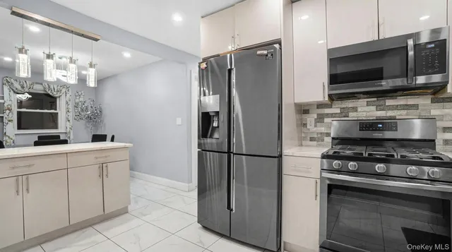 a kitchen with stainless steel appliances a refrigerator stove and microwave
