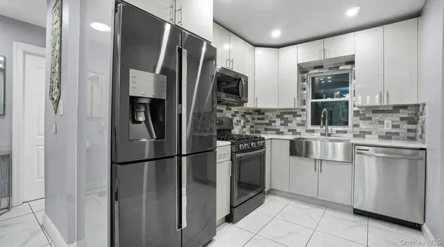 a kitchen with stainless steel appliances a refrigerator sink and microwave