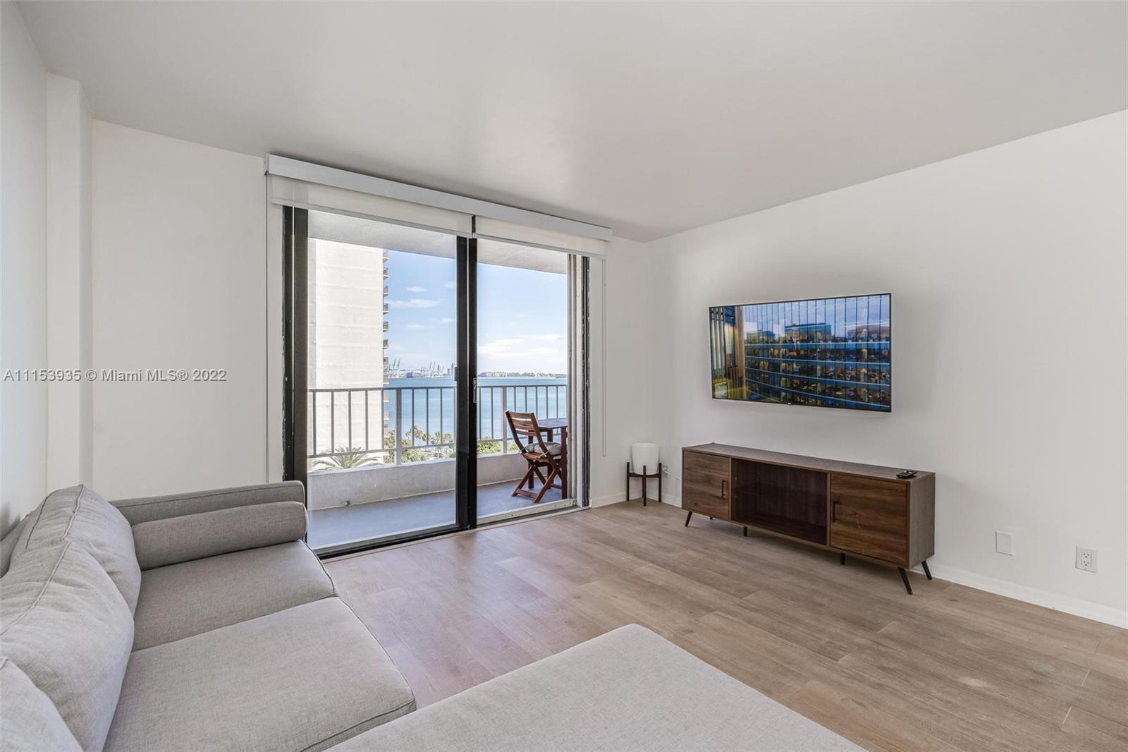 200 Southeast 15th Road, Unit 11H Miami, FL 33129 - Photo 10 of 20 a living room with furniture and a floor to ceiling window
