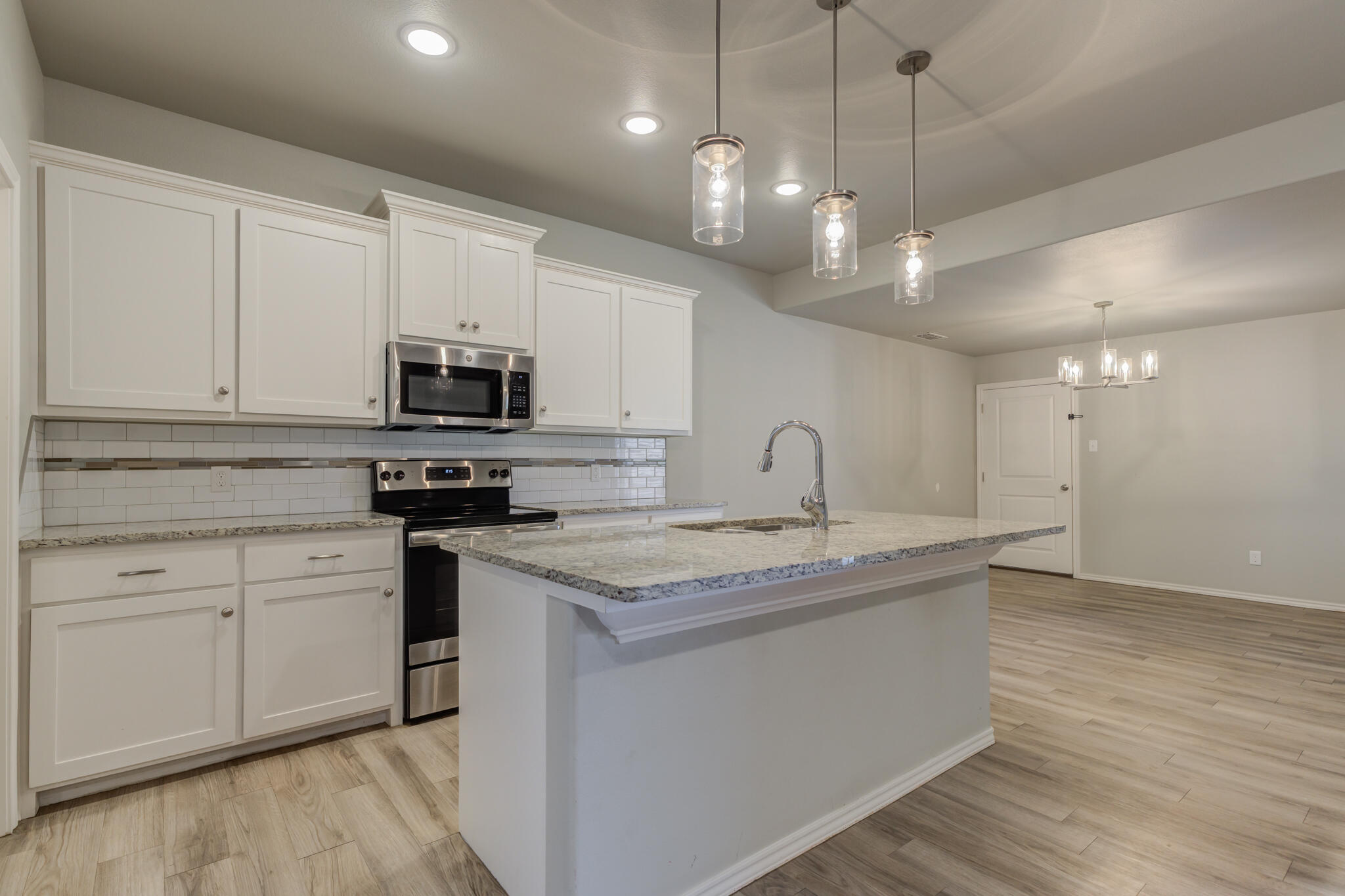 6906 67th Street Lubbock, TX 79424 - Photo 13 of 35 a kitchen with kitchen island granite countertop a sink a counter space appliances and cabinets