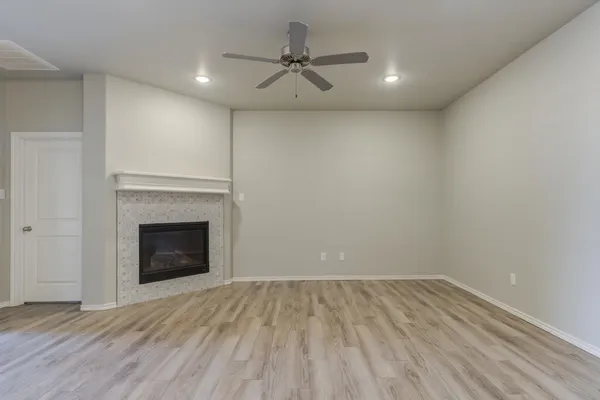a view of empty room with wooden floor and fireplace