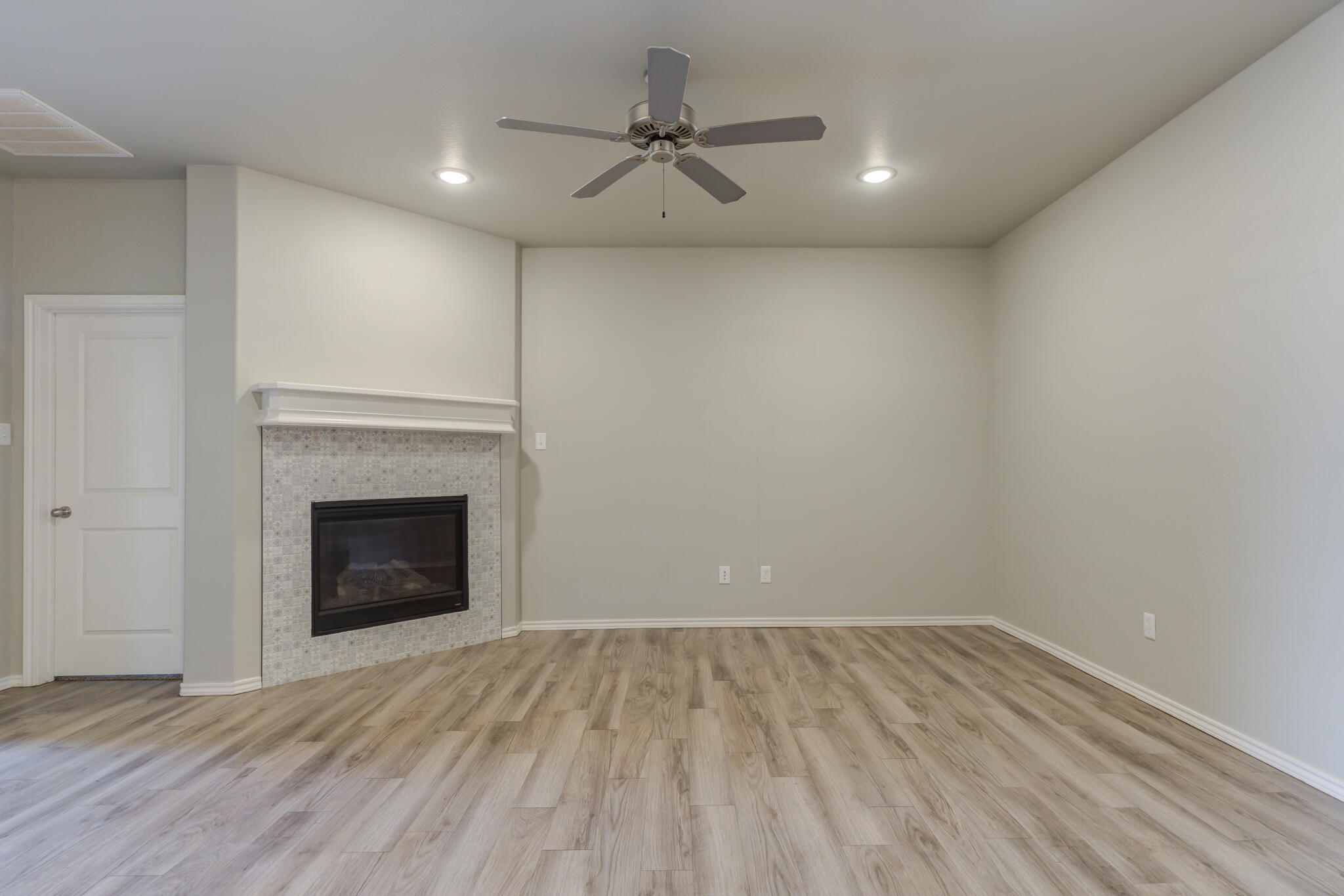 6906 67th Street Lubbock, TX 79424 - Photo 14 of 35 a view of empty room with wooden floor and fireplace