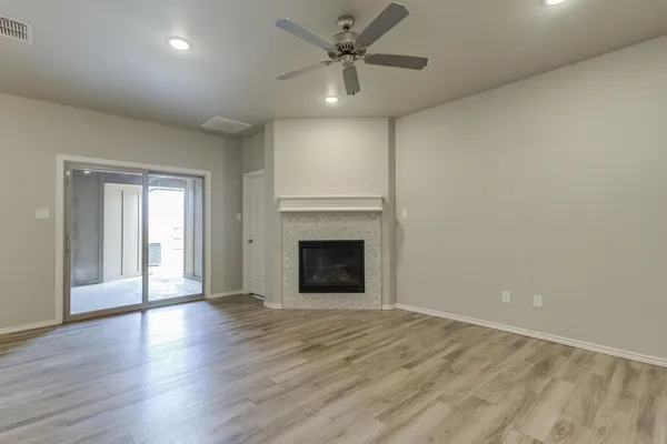 a view of an empty room with a fireplace and a window